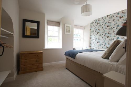 a bedroom with a bed with a blue patterned wall at Fellfoot Cottage in the Lake District in Staveley