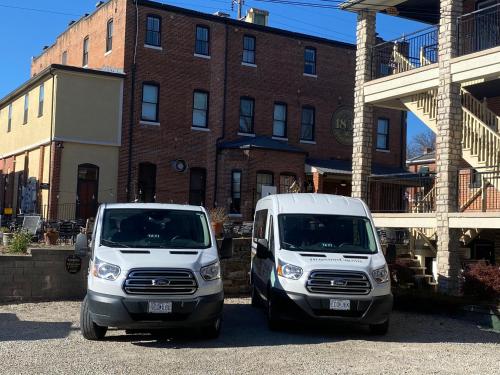 two white vans parked in front of a brick building at Hermann Crown Suites in Hermann