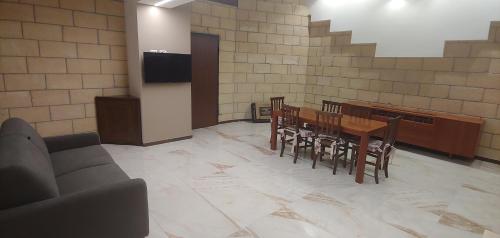 a dining room with a table and chairs and a tv at La Piana Hotel in Tito