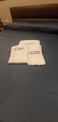 two white pillows sitting on top of a bed at La Piana Hotel in Tito