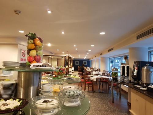 un restaurante con una línea de buffet con platos de comida en Jura Hotels Mavi Sürmeli Adana, en Adana