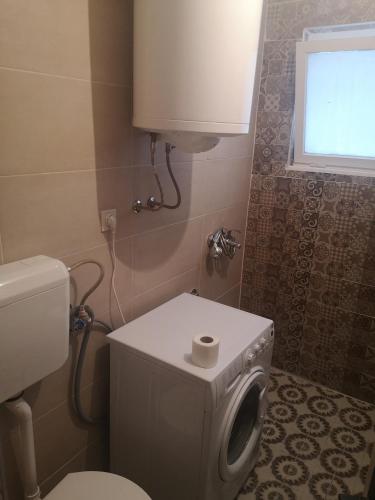 a bathroom with a toilet and a washing machine at White Night in Skopje