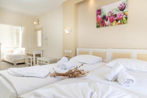 two white beds in a room with flowers on them at Villa Harmony in Agia Anna Naxos