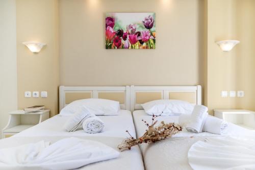two white beds in a room with flowers on the wall at Villa Harmony in Agia Anna Naxos