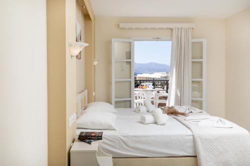 two beds in a room with a window at Villa Harmony in Agia Anna Naxos
