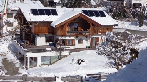a house with solar panels on the roof in the snow at Haus Patricia in Kartitsch