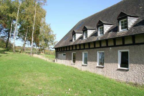 a building with a grass field next to a house at Die Strumpffabrik - Guesthouse in Kerpen