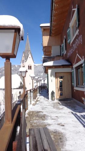 a street with a wooden bench and a building at Gasthaus Dorfberg in Kartitsch