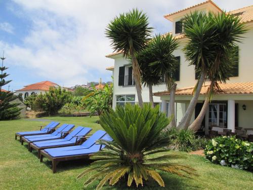 a group of lounge chairs in the yard of a house at Quinta Alegre in Calheta