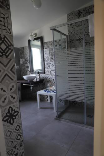a bathroom with a shower and a sink and a mirror at Il Borgo Suite in Cerignola