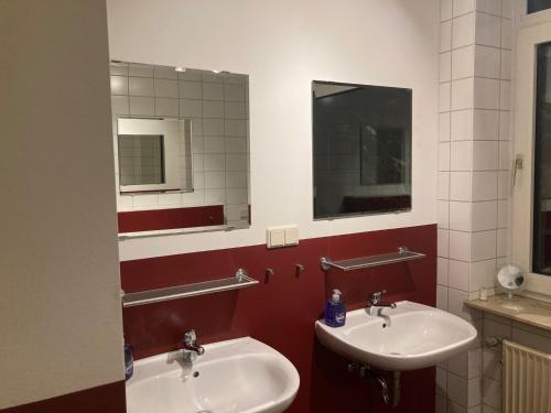 a bathroom with two sinks and a mirror at Apartmenthaus in Lingen
