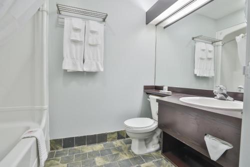 a white bathroom with a sink and a toilet at Comfort Inn & Suites in Saint-Jérôme