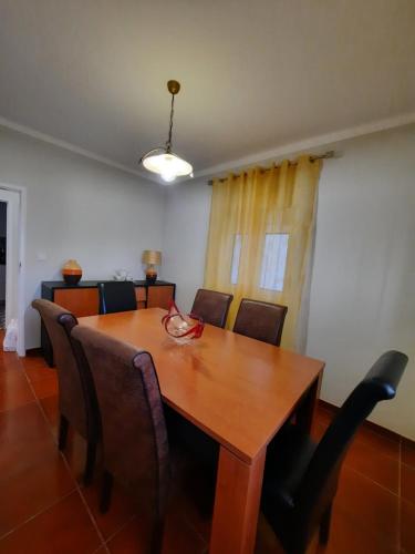 a dining room with a wooden table and chairs at CASA DO NINHO - Entre o Campo e a Praia in Cadaval