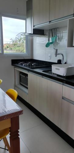 a kitchen with a stove and a sink and a table at Beira Mar Village in Pinheira