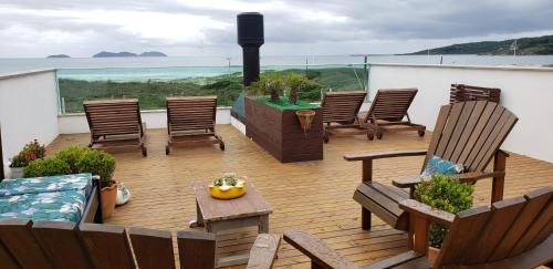 a patio with chairs and a table with a view of the ocean at Beira Mar Village in Pinheira