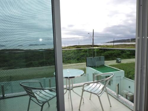 a balcony with a table and chairs and a view of the ocean at Beira Mar Village in Pinheira