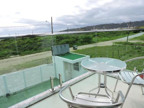 a balcony with a table and chairs and a bridge at Beira Mar Village in Pinheira