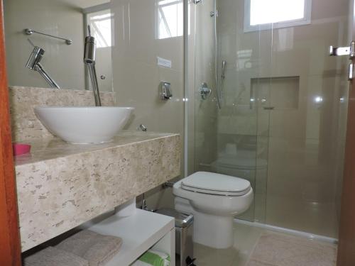a bathroom with a sink and a toilet and a shower at Beira Mar Village in Pinheira