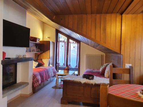 1 Schlafzimmer mit 2 Betten, einem TV und einem Kamin in der Unterkunft DELIZIOSA MANSARDA in Madonna di Campiglio
