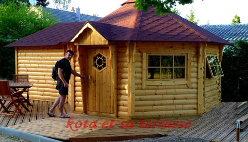 a man standing in front of a log cabin at La Vallée du Cher in Monthou-sur-Cher