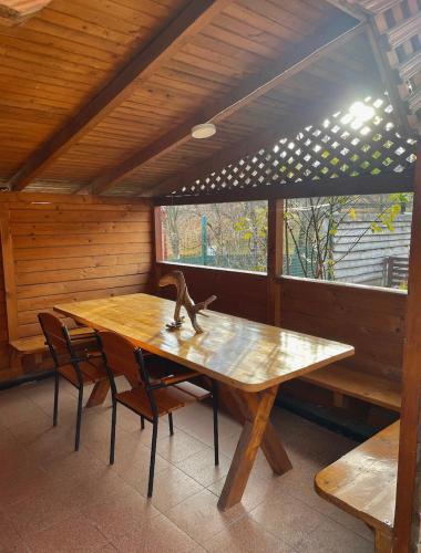 un tavolo e delle sedie di legno in una stanza con una finestra di Yaremche House a Jaremče