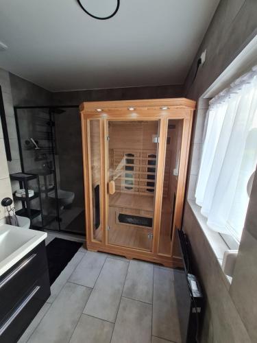 W łazience znajduje się prysznic i drewniana szafka. w obiekcie Słoneczny Zakątek w mieście Lubrza