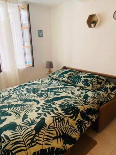 - une chambre avec un lit et une couette verte et blanche dans l'établissement Studio Sérénité-La Roquette-Rue très calme, à Arles