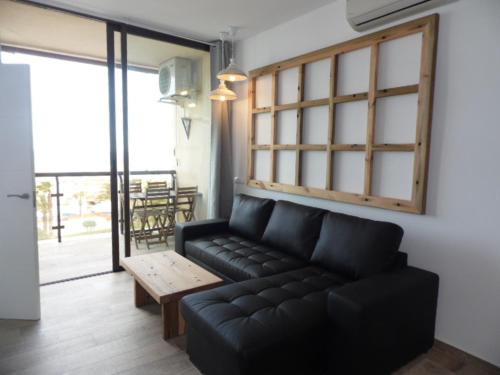 a living room with a black couch and a table at Puerto Marina in Benalmádena