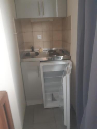 une petite cuisine avec un évier et une cuisinière dans l'établissement Gîte de Bénédicte Fribourg, à Colmar