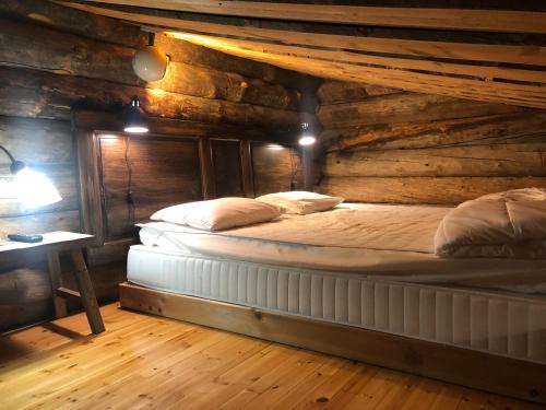 una camera con un letto in una baita di tronchi di Rukanloiste a Ruka