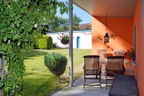 a patio with two chairs and a table in a yard at Ferienhaus Fam_ Lemke in Bergen auf Rügen