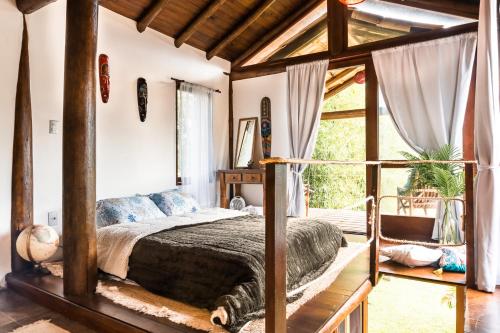 En eller flere senge i et værelse på Casa super charmosa na Praia do Rosa.