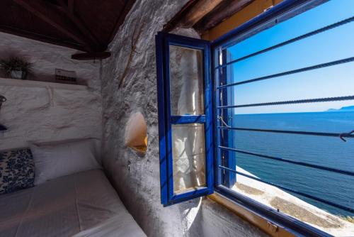 a bedroom with a window with a view of the ocean at Villea Seaview Apartments in Skopelos Town