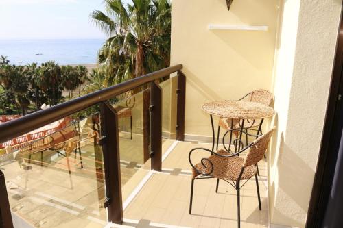 a balcony with a table and chairs and the ocean at Puerto Marina in Benalmádena
