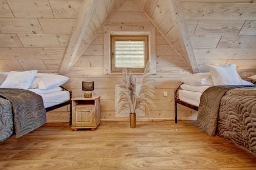 two beds in a room with a attic at Jędroskowe Chatki in Witów