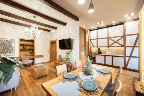 a dining room and living room with a table and chairs at Krakowhomes in Kraków