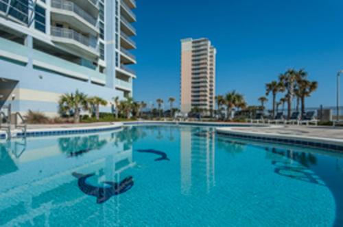 a large swimming pool with a building in the background at Emerald Dolphin unit 650 in Pensacola Beach
