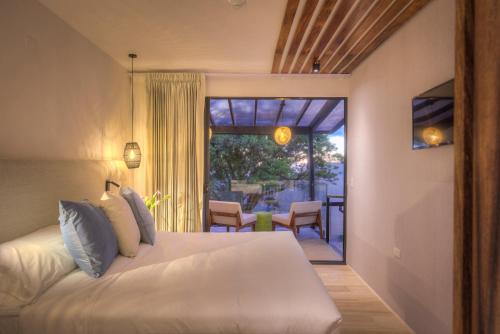 1 dormitorio con 1 cama blanca y patio en Ocotea Boutique Hotel, en Monteverde