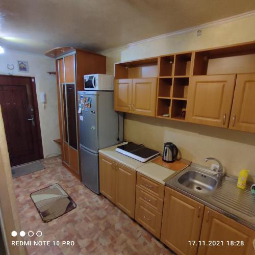 a small kitchen with a sink and a refrigerator at Посуточно! Уютная, 1 квартира Олимпийская, новые дома. in Kharkiv