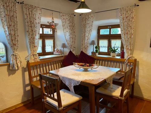a dining room with a table and chairs and windows at Jurahaus Hirschberg EG Wohnung in Beilngries