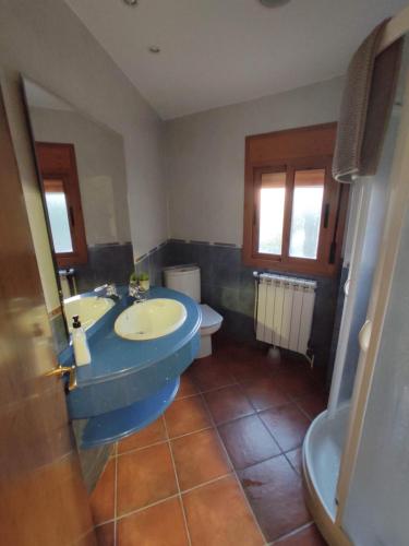 uma casa de banho com um lavatório azul e um WC. em Cal Ferrer em Poboleda