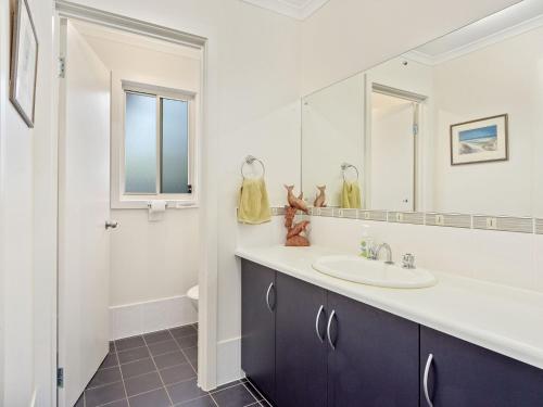 een badkamer met een wastafel en een spiegel bij Decked Out at Dolphin 31 Dolphin Avenue in Carrickalinga