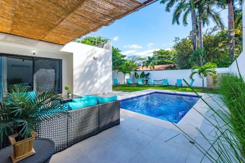 a villa with a swimming pool and a patio at Ultramodern Townhome with an Inviting Coastal Design and Lush Outdoor Oasis with a Private Pool in Playa Flamingo