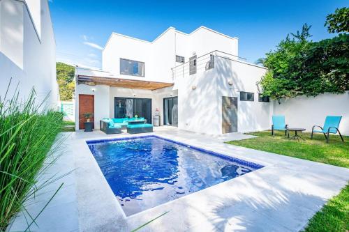 a swimming pool in the backyard of a house at Ultramodern Townhome with an Inviting Coastal Design and Lush Outdoor Oasis with a Private Pool in Playa Flamingo
