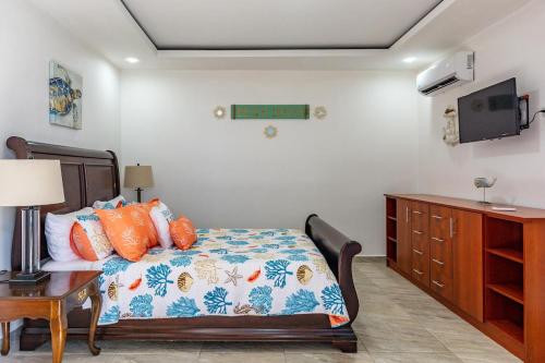 a bedroom with a bed and a desk and a tv at Ultramodern Townhome with an Inviting Coastal Design and Lush Outdoor Oasis with a Private Pool in Playa Flamingo