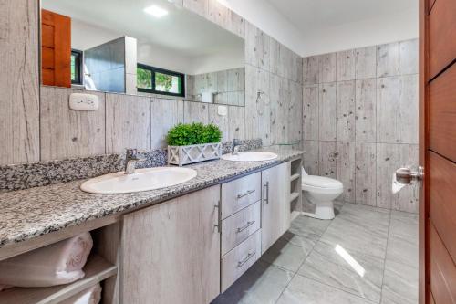 a bathroom with two sinks and a toilet at Ultramodern Townhome with an Inviting Coastal Design and Lush Outdoor Oasis with a Private Pool in Playa Flamingo