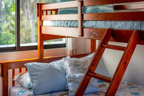 a bunk bed with a couch under a bunk bed at Ultramodern Townhome with an Inviting Coastal Design and Lush Outdoor Oasis with a Private Pool in Playa Flamingo