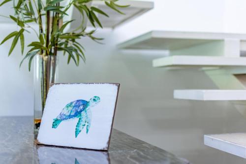 a drawing of a turtle on a table with a vase at Ultramodern Townhome with an Inviting Coastal Design and Lush Outdoor Oasis with a Private Pool in Playa Flamingo