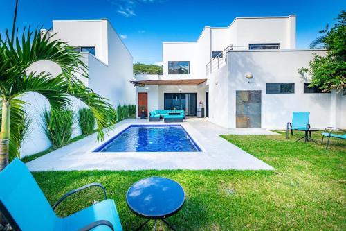 a house with a swimming pool in the yard at Ultramodern Townhome with an Inviting Coastal Design and Lush Outdoor Oasis with a Private Pool in Playa Flamingo