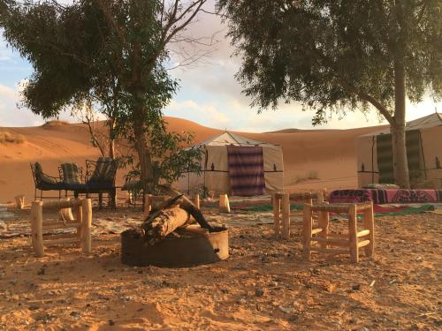 a person laying in a tub in the desert at Nomad Desert House in Merzouga